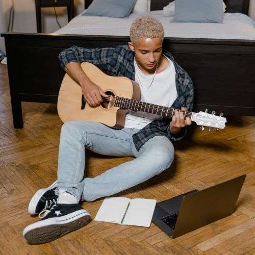 Young-man-learning-guitar-online